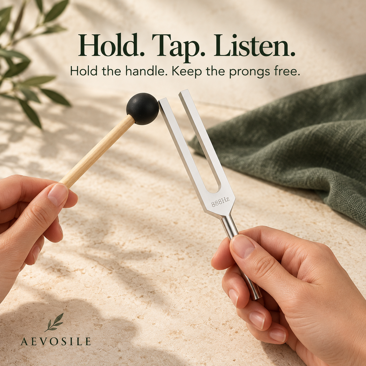 Holding the 888 Hz tuning fork handle while gently tapping one prong with a rubber mallet